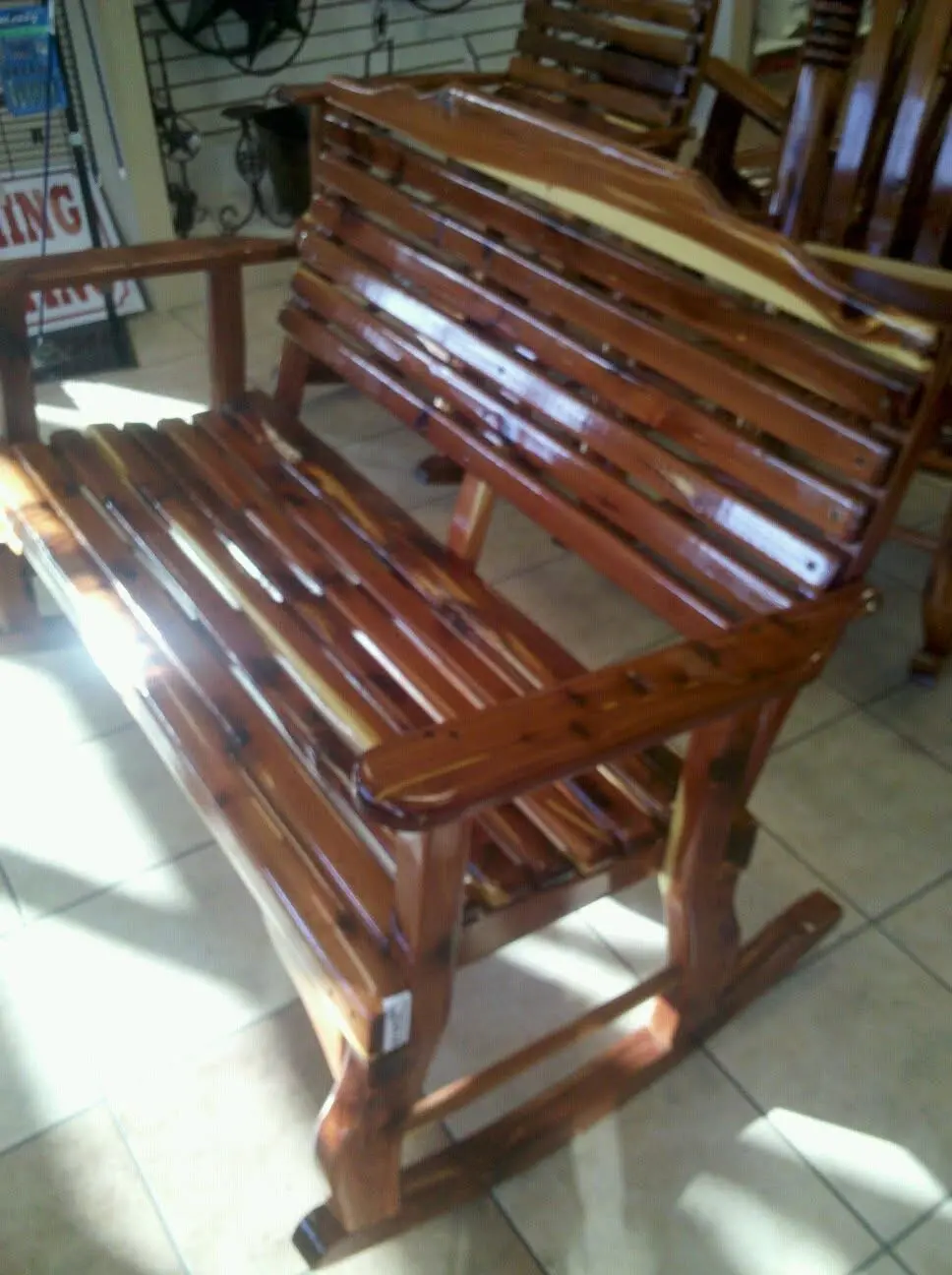 Slatted cedar rocking bench with curved armrests