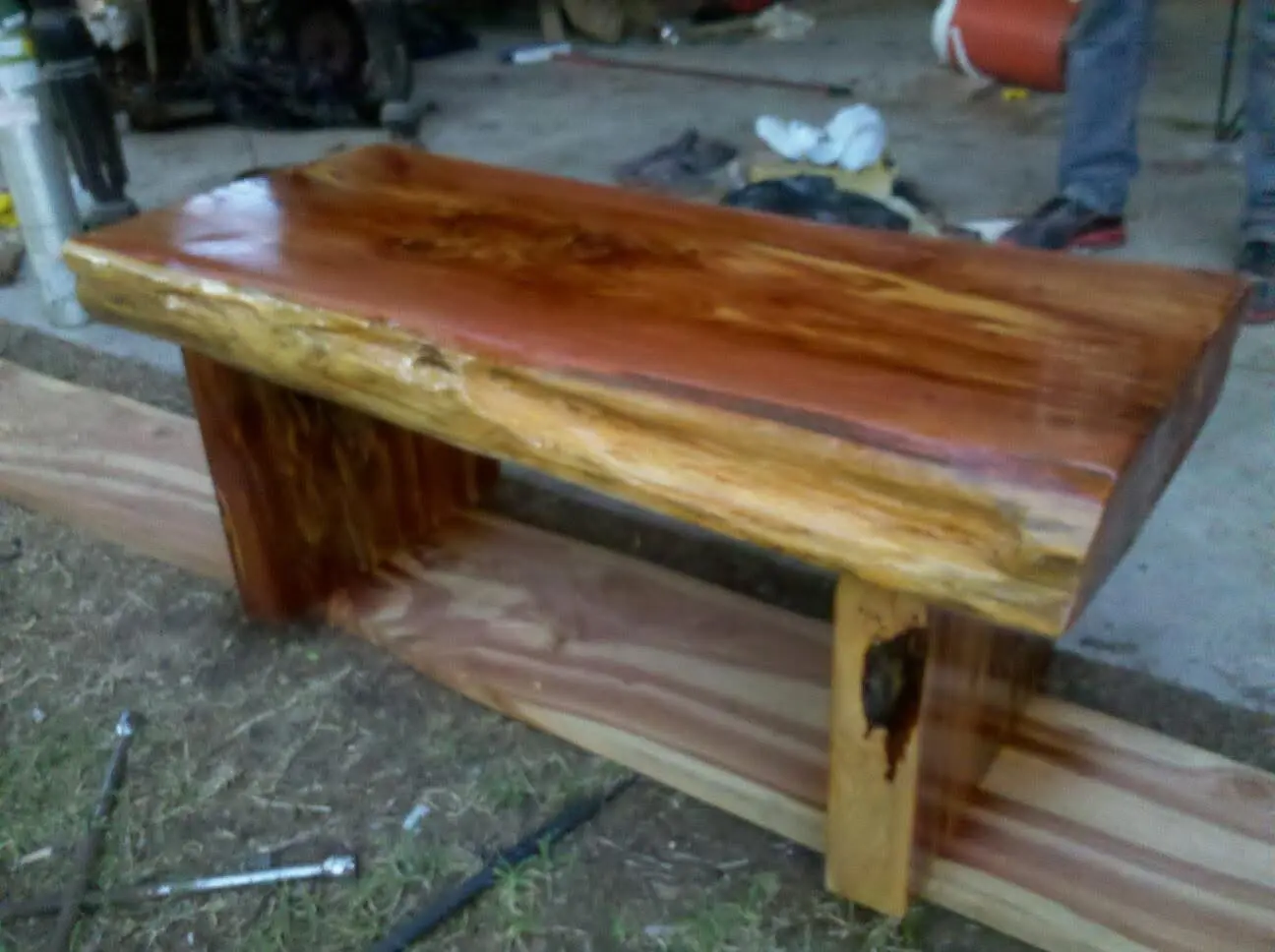 Thick cedar slab bench with a glossy finish and natural bark edge