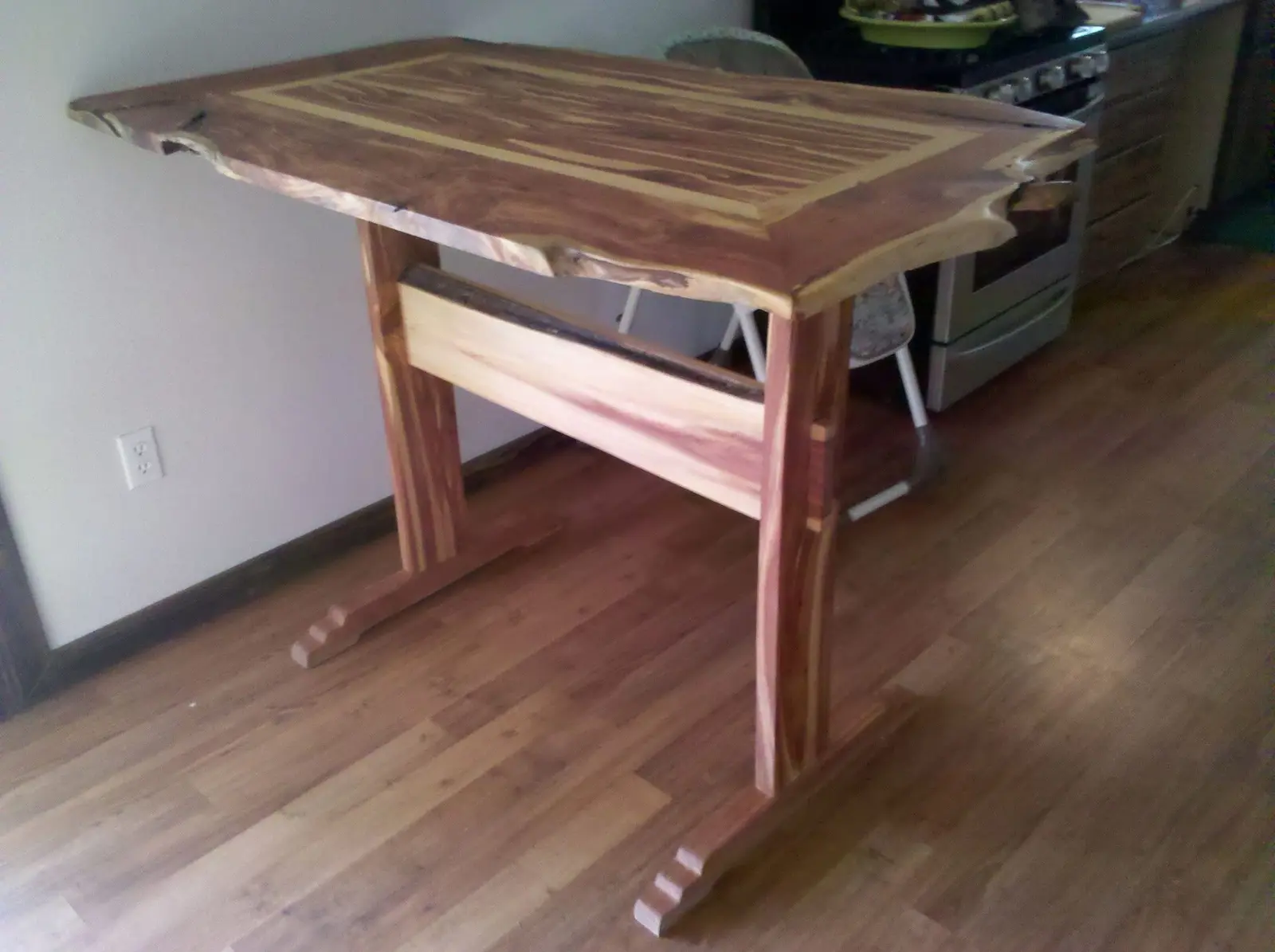 Cedar trestle table with a live-edge border around a book-matched plank top
