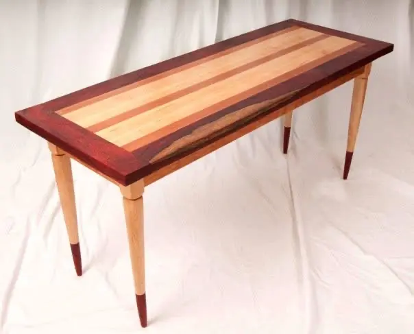 Sofa table with a striped maple and padauk top on tapered maple legs with dark tips