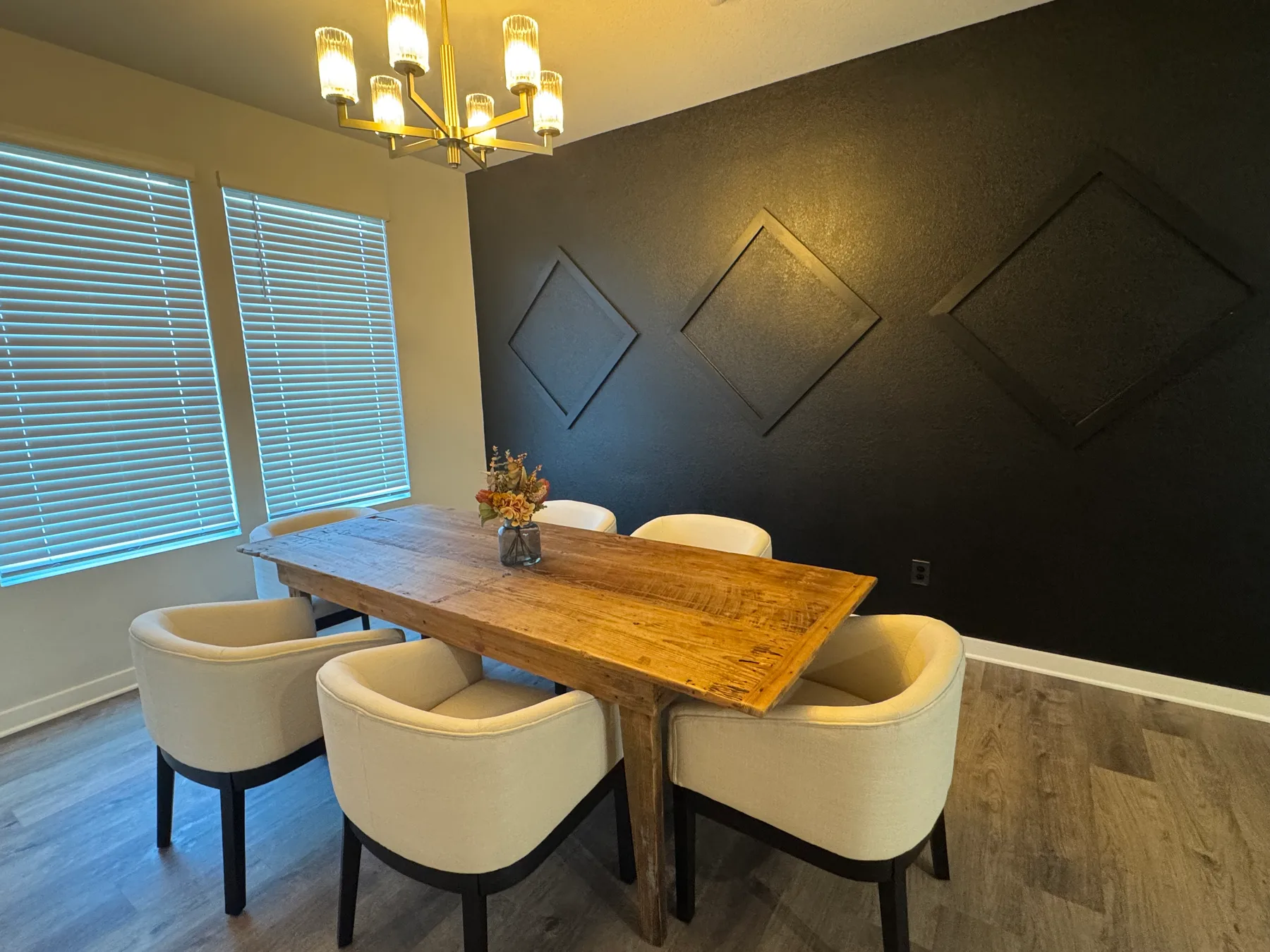 Reclaimed longleaf pine dining table against a black accent wall in a client's dining room